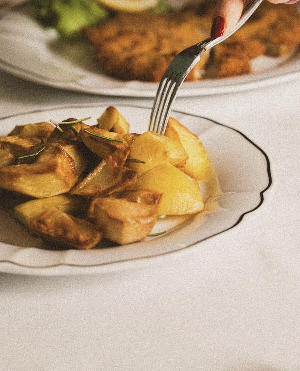 Patate arrosto al rosmarino sul piatto a filo nero